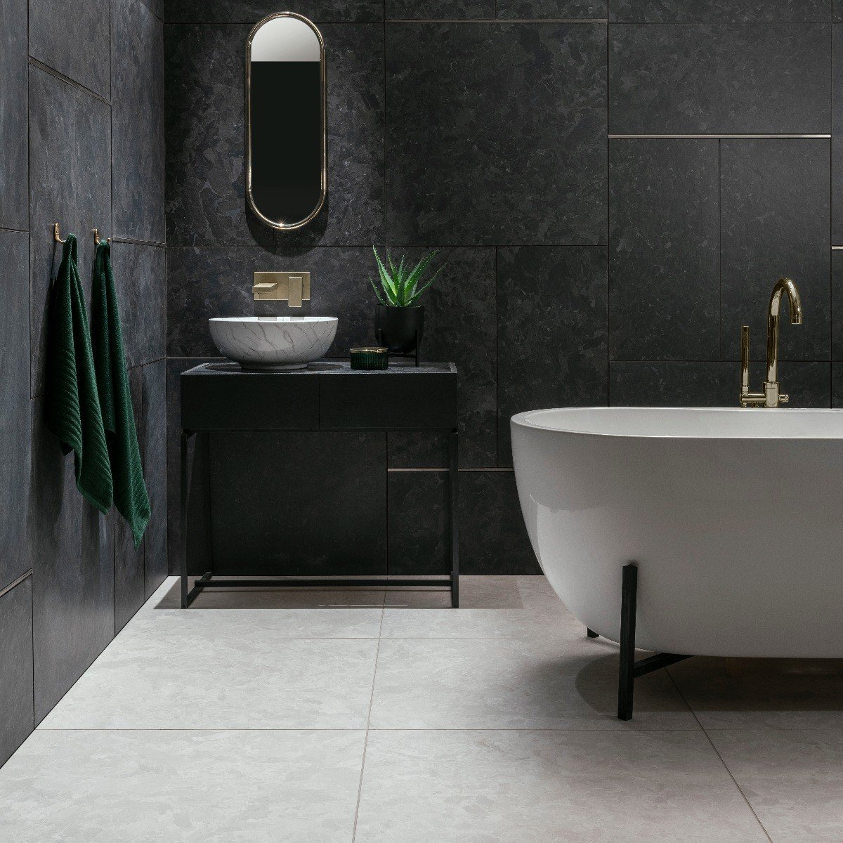 Solo Topps Tiles With white ceramic bath tub, wash basin and toilet with mosaic tiled walls and marble fragments bathroom black and white color. solo black 80cm x 80cm
